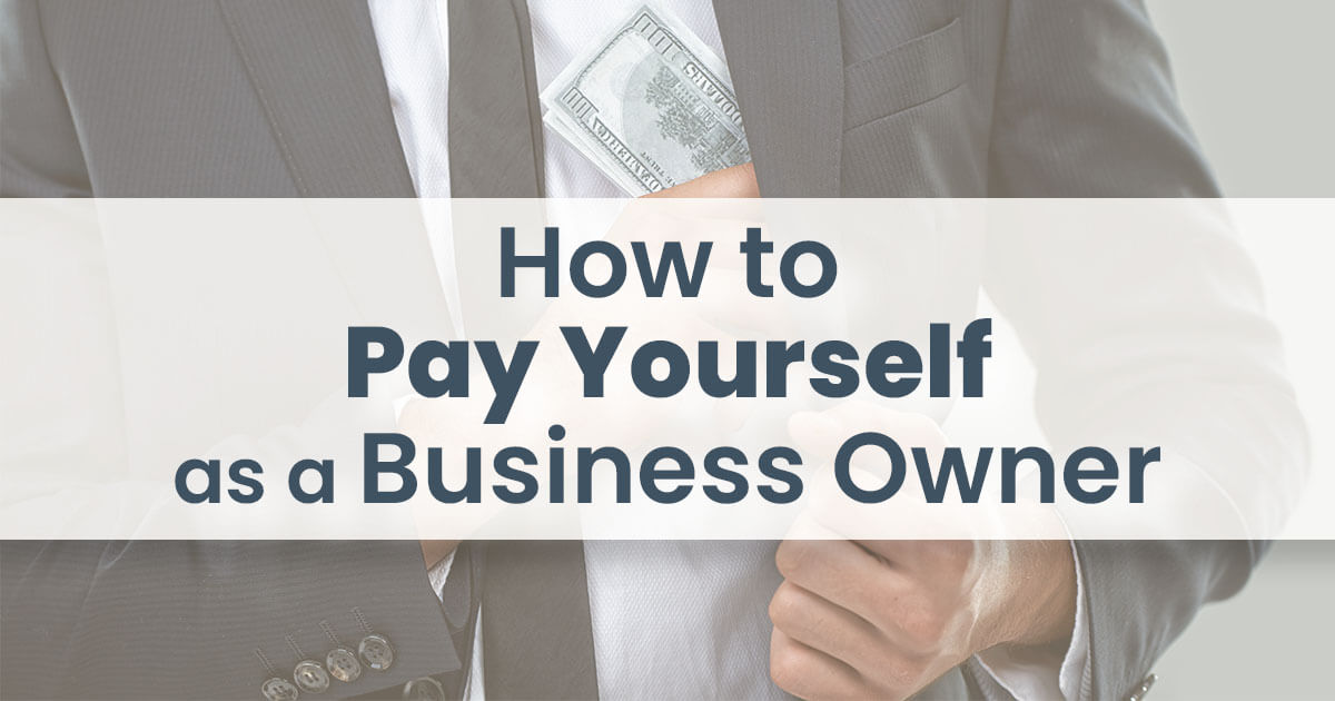 How to pay yourself as a business owner. A man stuffing 100 dollar bills in the inside pocket of his business suit.