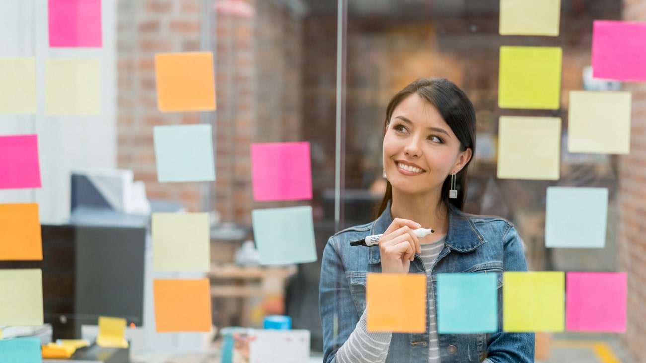 Small business owner planning next steps on colorful notes