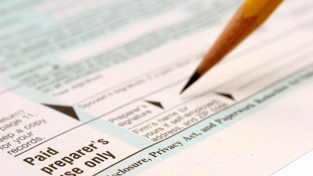 Close-up of a pencil pointing at terms "preparer’s use only" on a form, highlighting confidentiality sections regarding personal information.