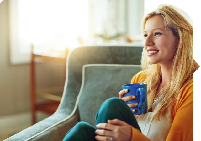 Mujer tomando café sentada en el sofá