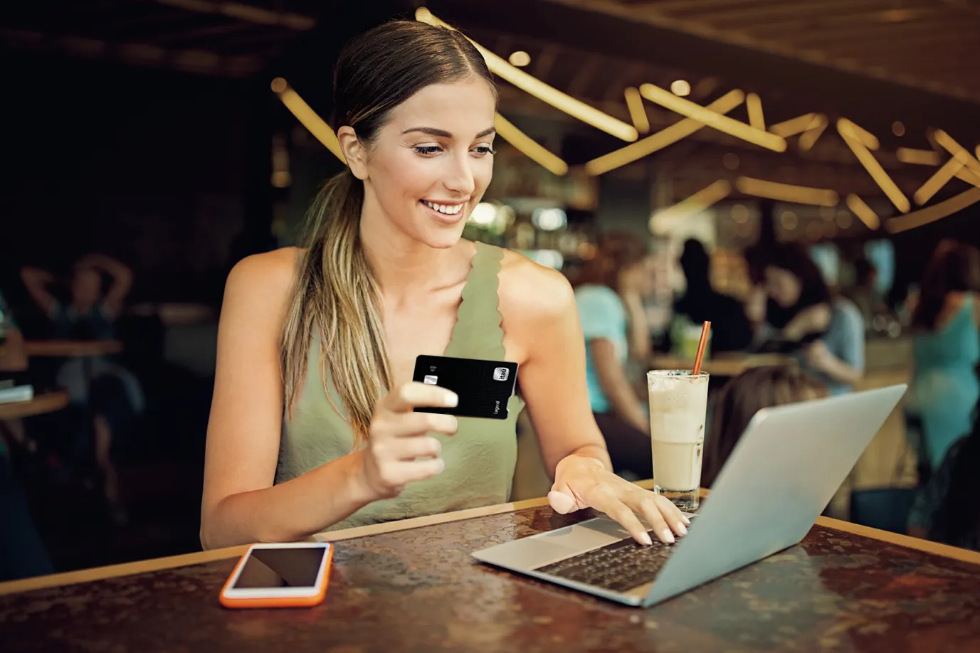 Mujer usando un computador y celular