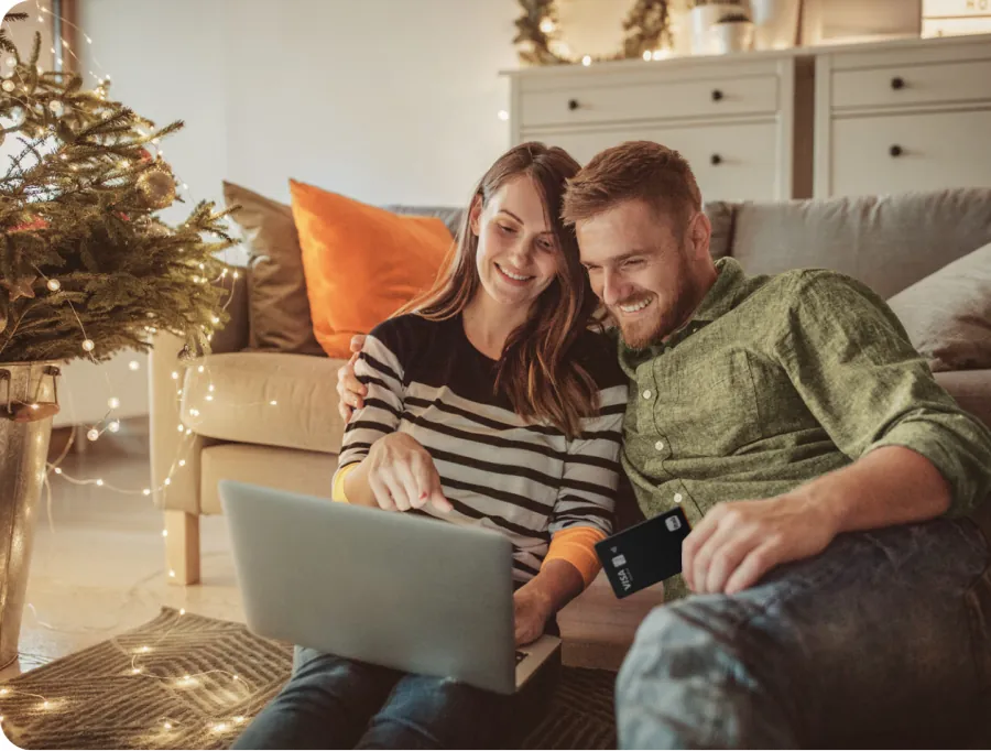 Mujer y hombre mirando un notebook con tarjeta en la mano