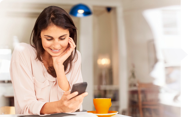 Mujer tomando un té mientras ve su celular