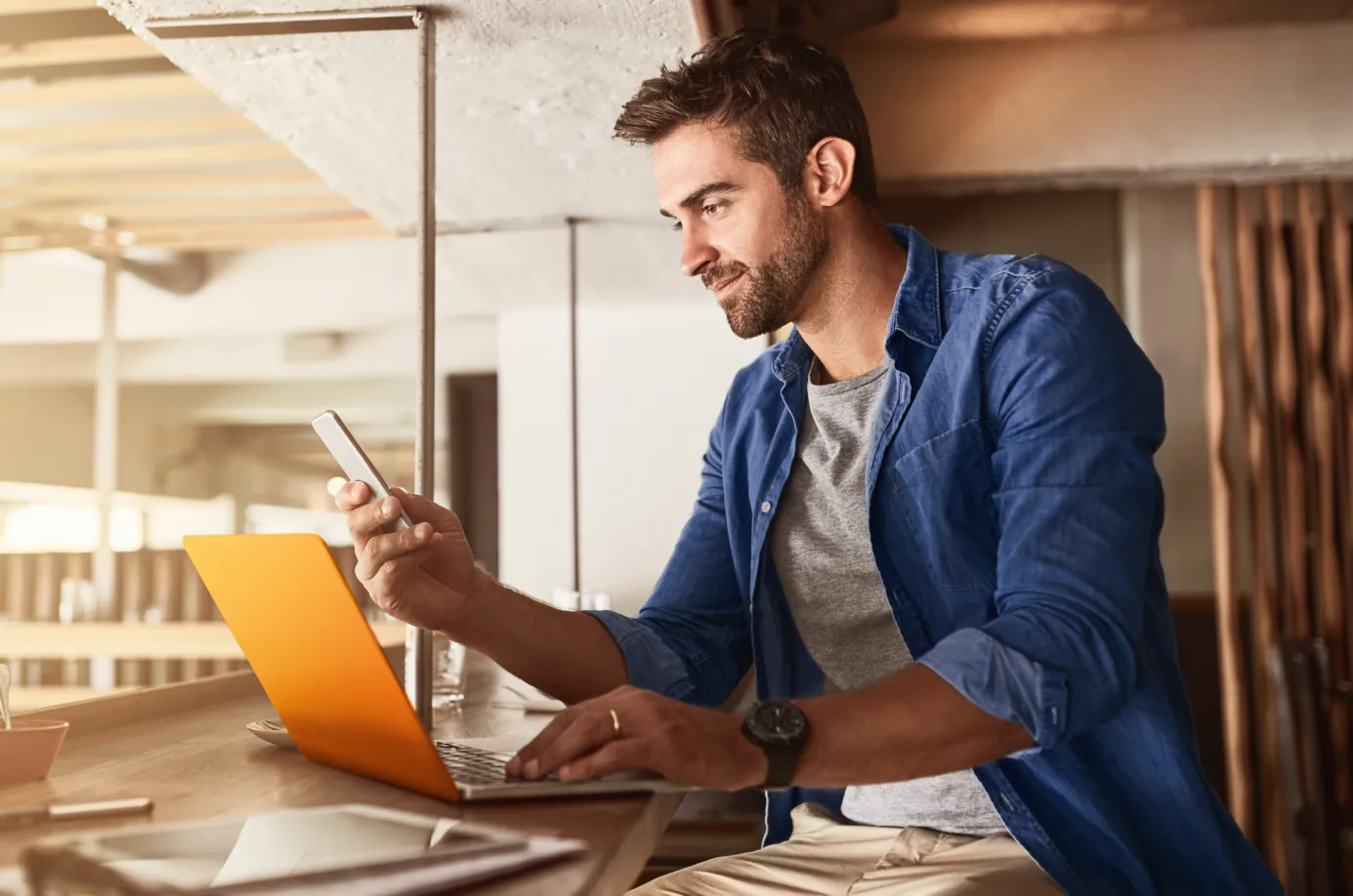 Hombre usando un computador y un celular