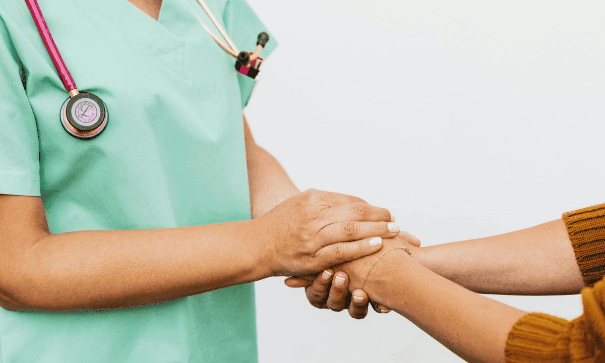image of doctor holding hand of her patient
