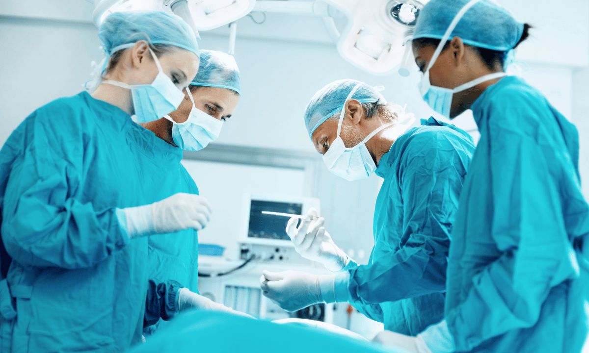 Team of surgeons wearing surgical gowns performing an operation