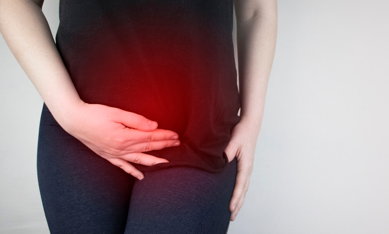 Woman holding her uterus suspect uterine fibroids and can it lead to cancer