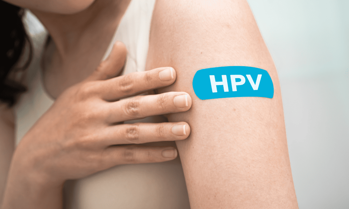 A photo of a person’s upper arm with a blue bandage that has 