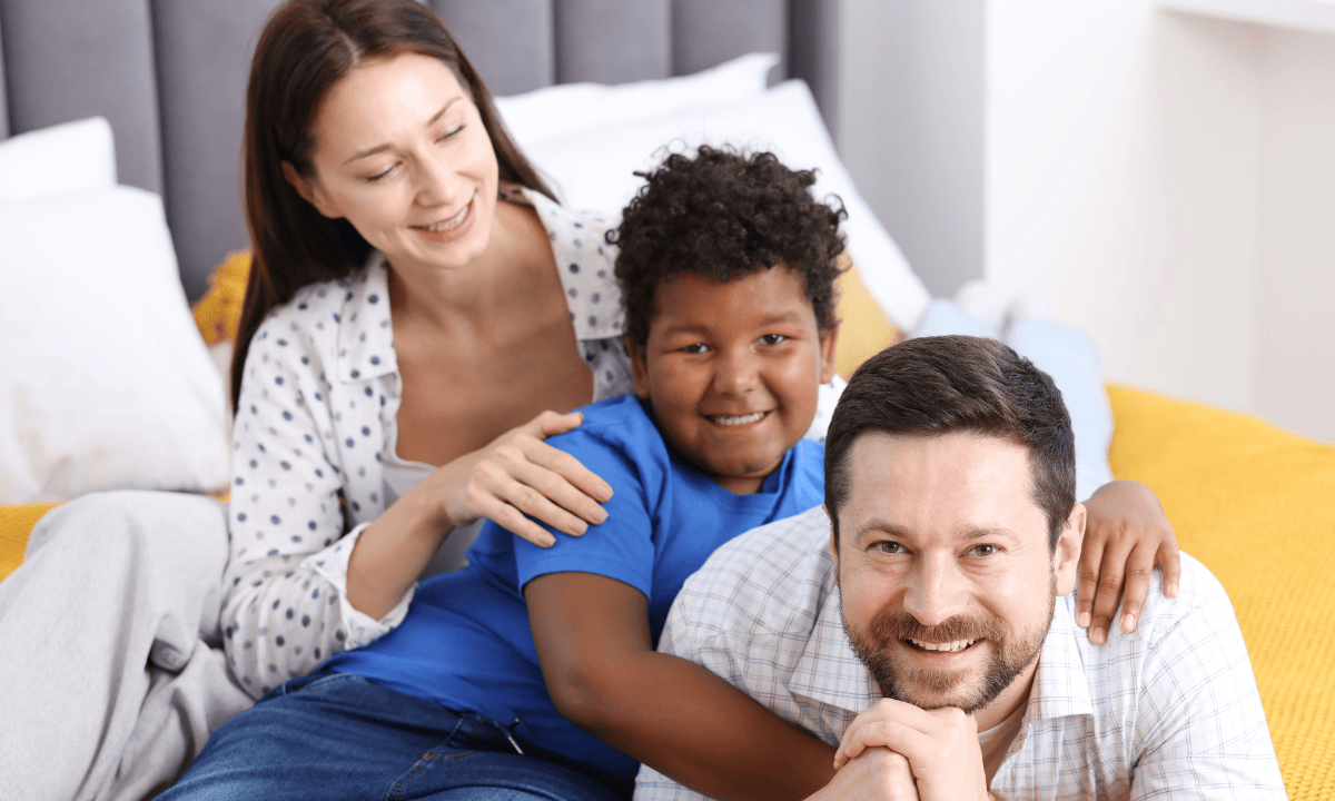 Family with parents and adopted child smiling together