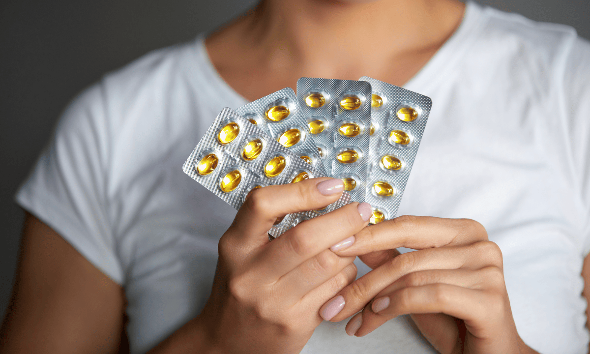 a woman holding birth control pills