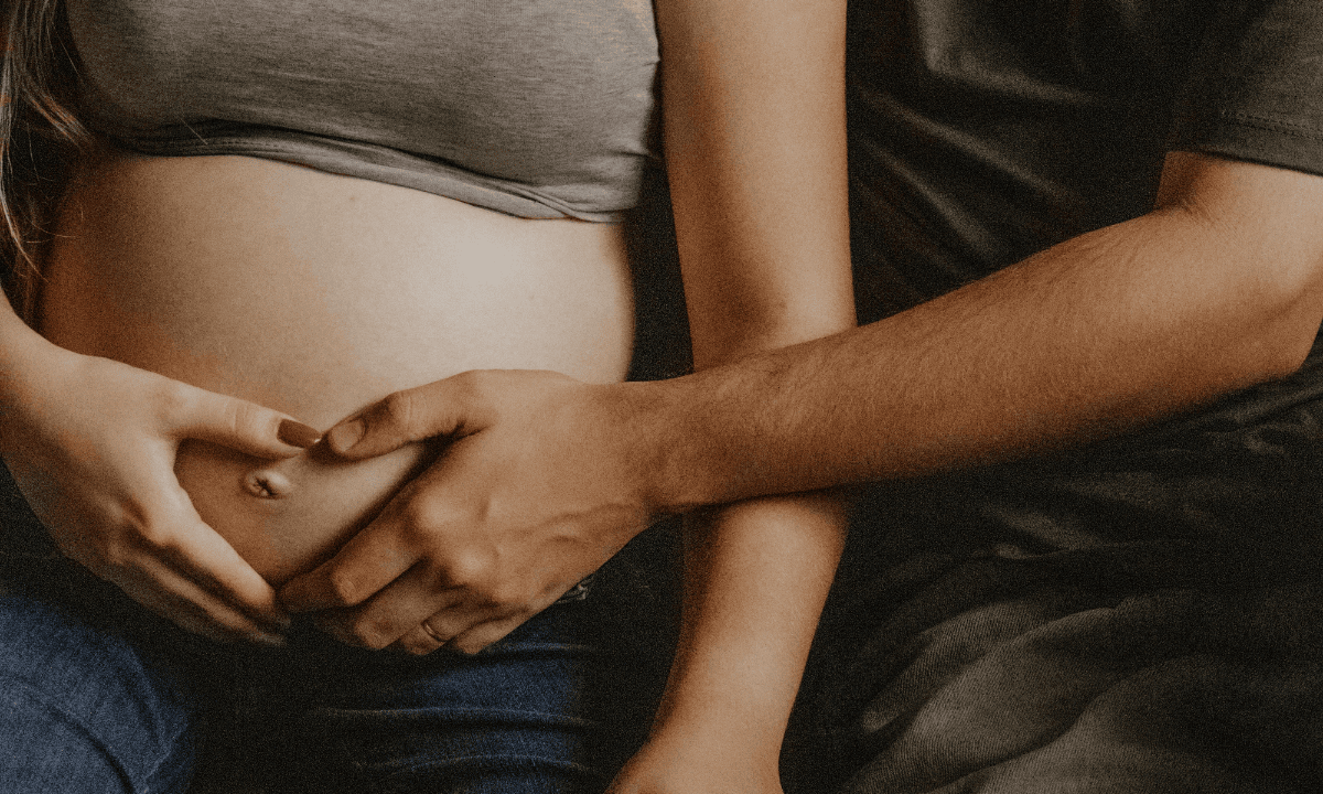 Husband holding his wife's pregnant stomach