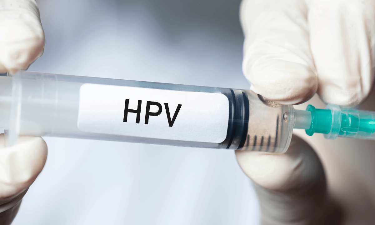 Image of hands holding a syringe of HPV vaccine