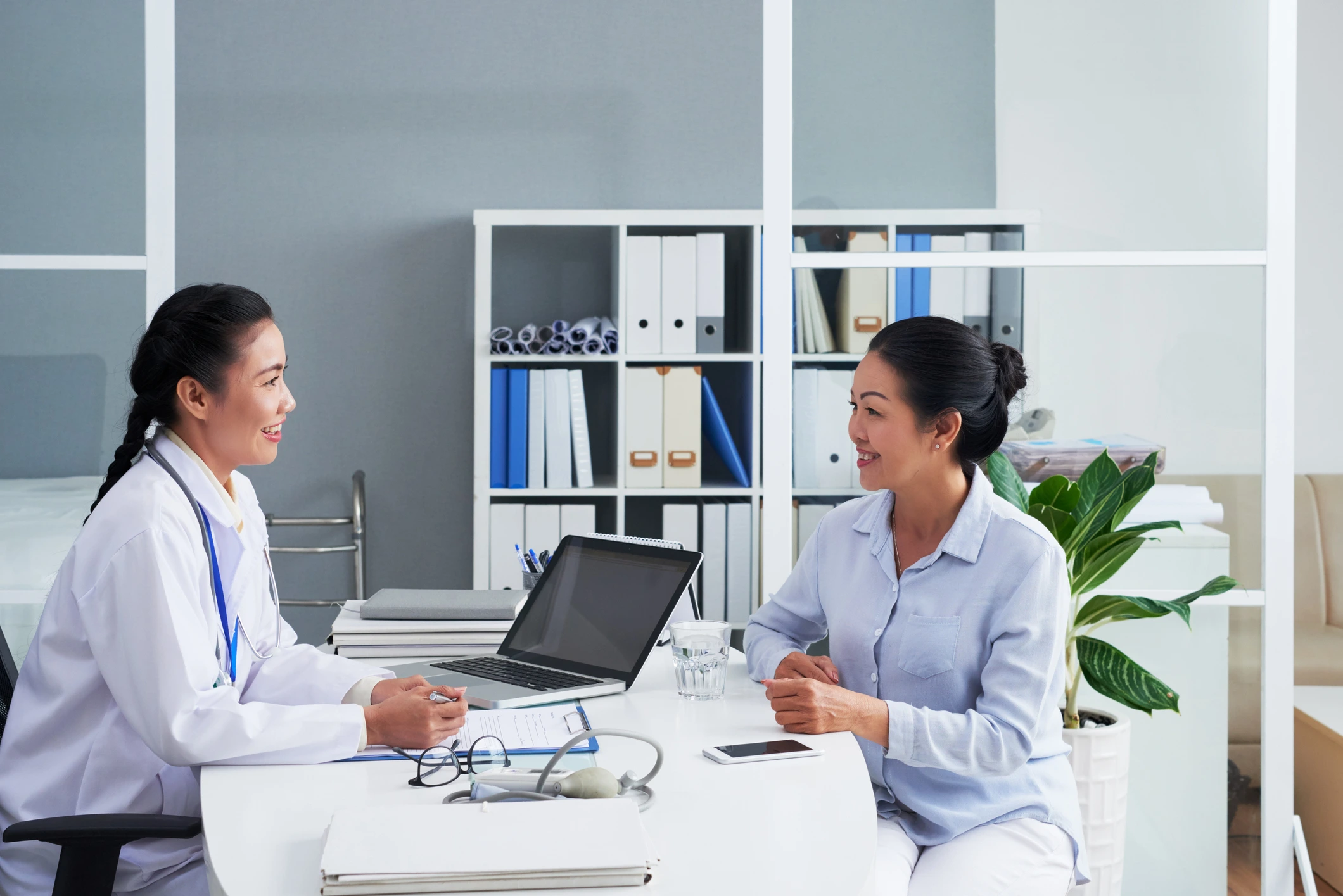 female doctor consulting woman patient in consult room seated at table obstetrics and gynaecology thomson medical women specialist health and wellness