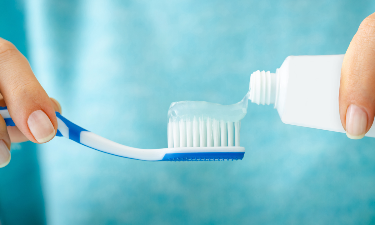 Applying toothpaste to a toothbrush.