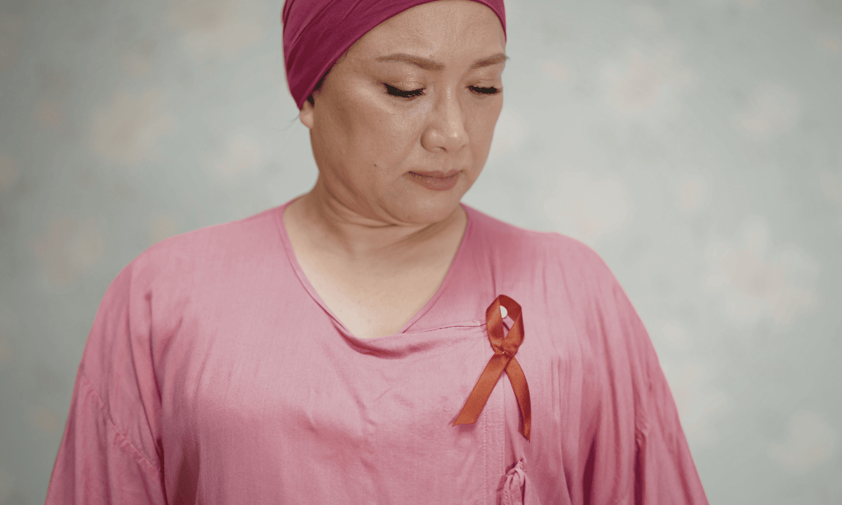 Woman wearing a pink headscarf and awareness ribbon