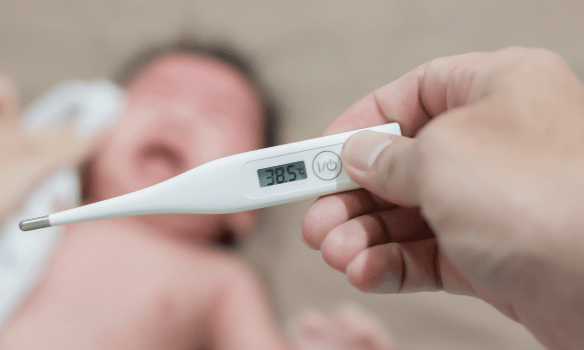 A photo of a thermometer showing 38.5°C, with a baby crying in the background