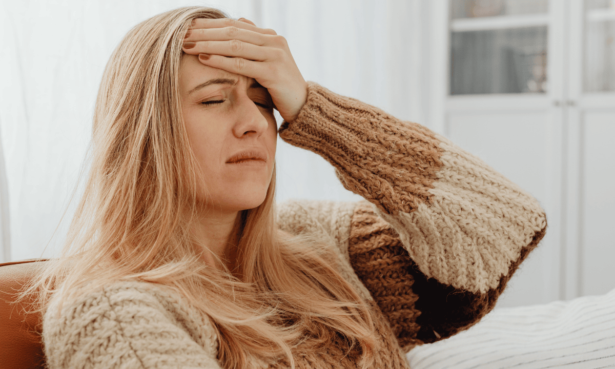 Woman wincing and touching her forehead
