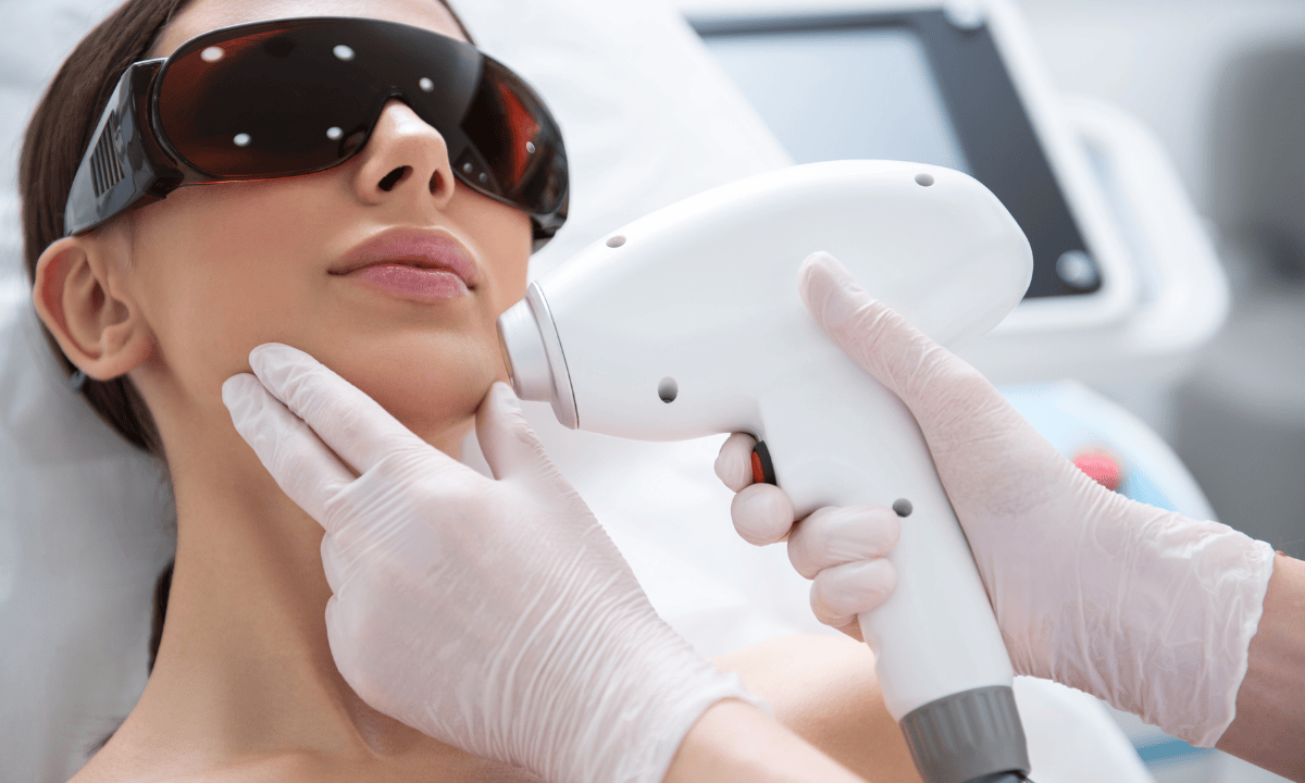 photo of woman performing a laser hair removal