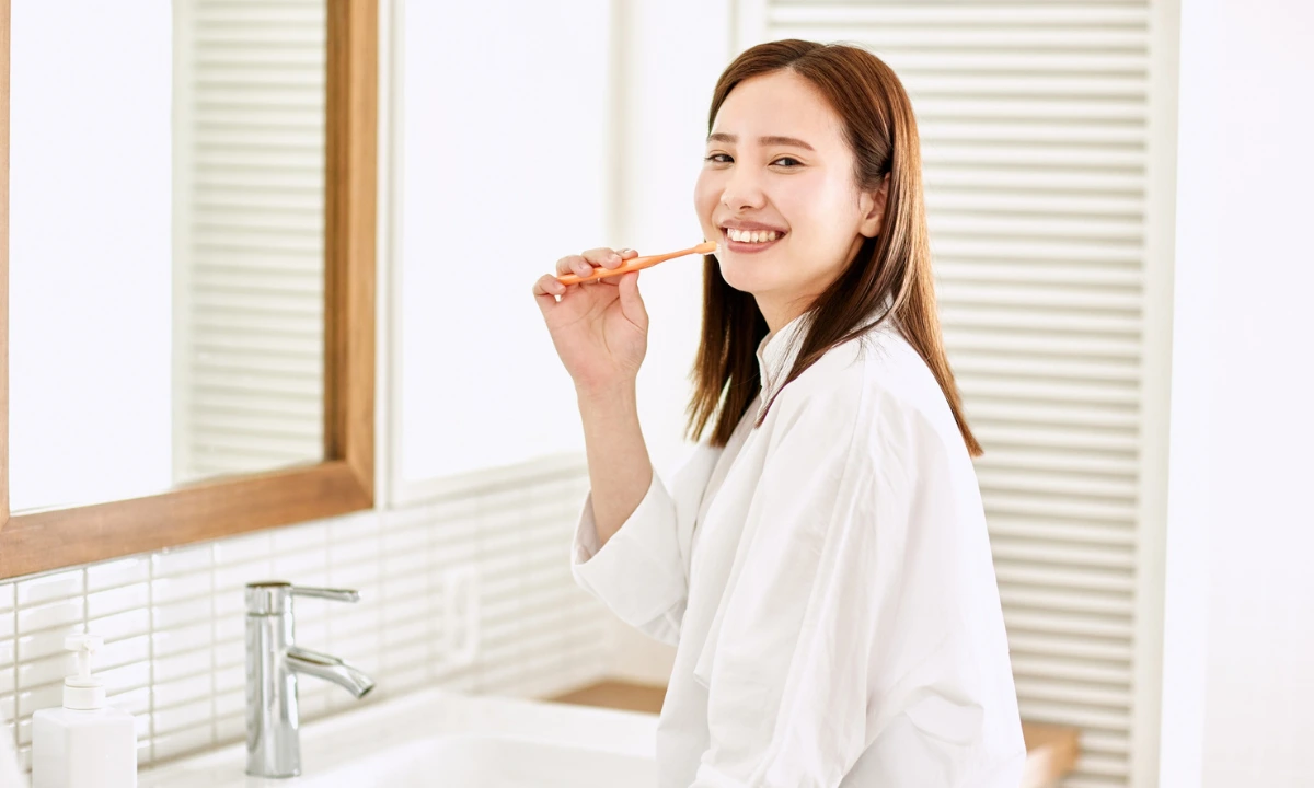 asian woman brushing her teeth