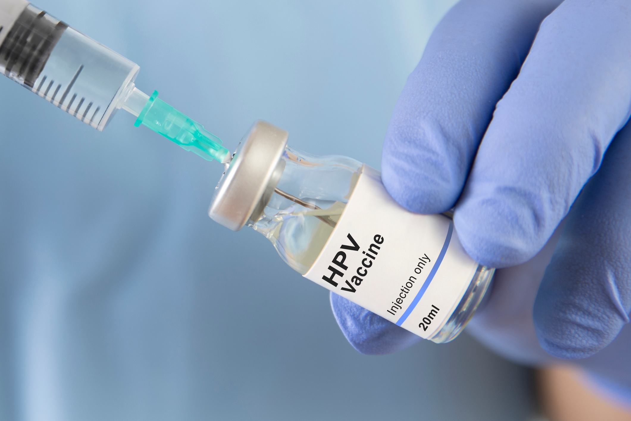 blue gloved hands preparing syringe with hpv vaccine for injection women vaccination sexual health