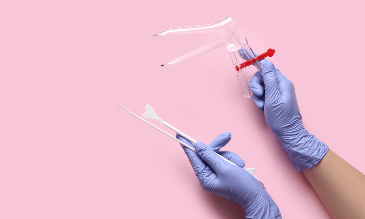 Gloved hands holding a plastic speculum and a cervical swab against a pink background