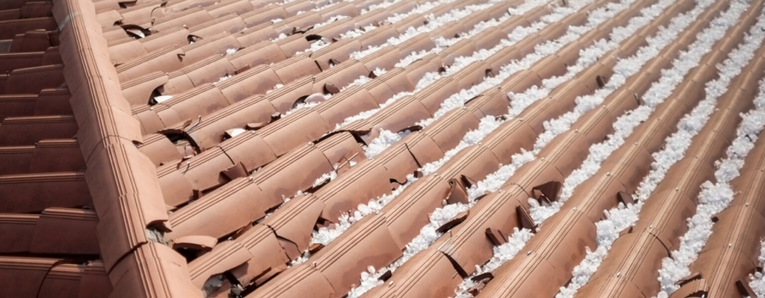 Damaged tile roof with hail in the cracks.