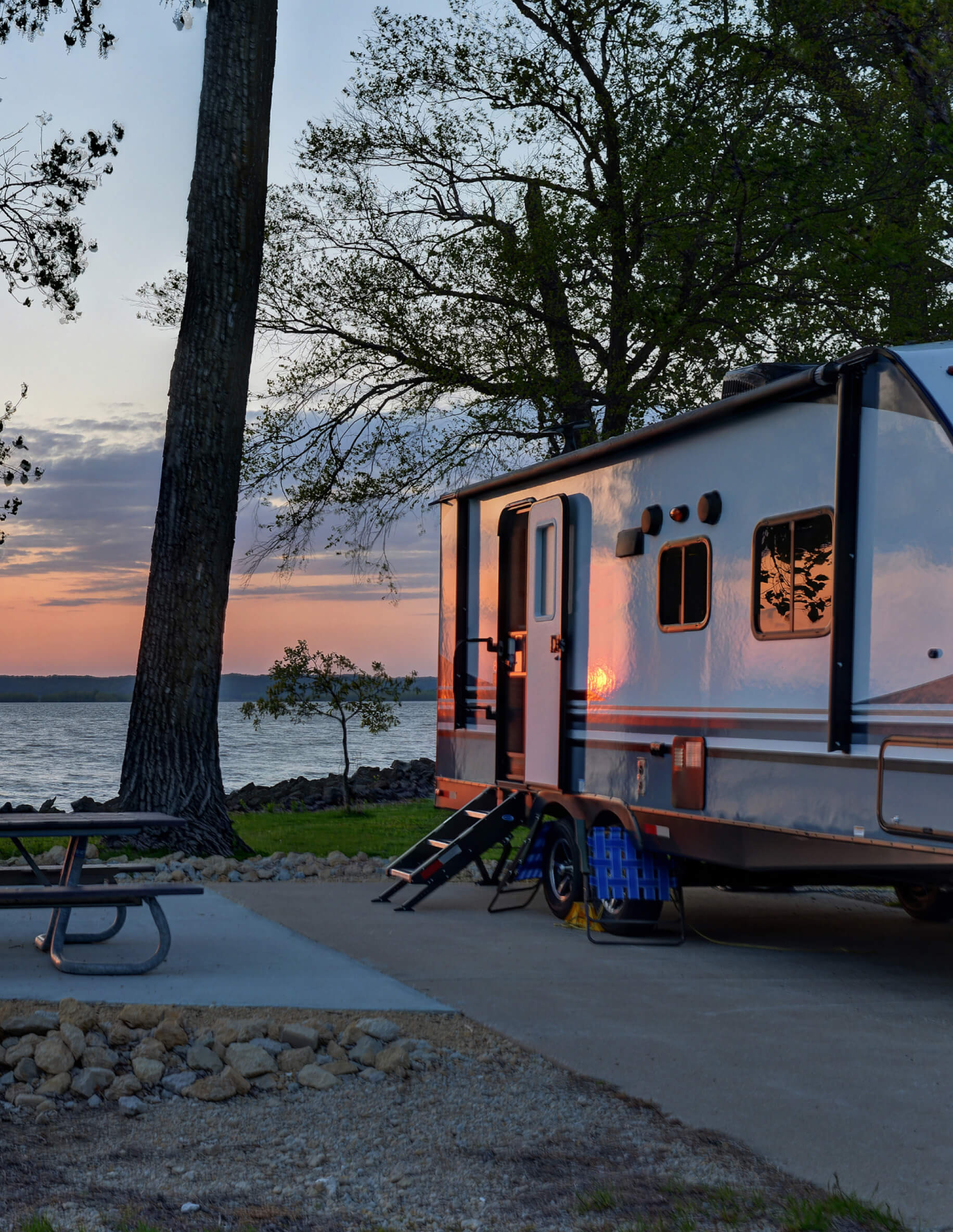 RV parked at the water with mountains in the background