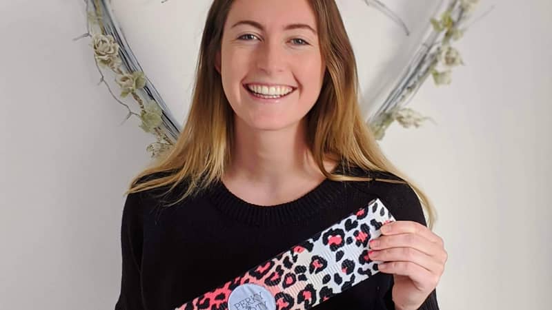 Founder of Perky Booty holding leopard print short fabric resistance band