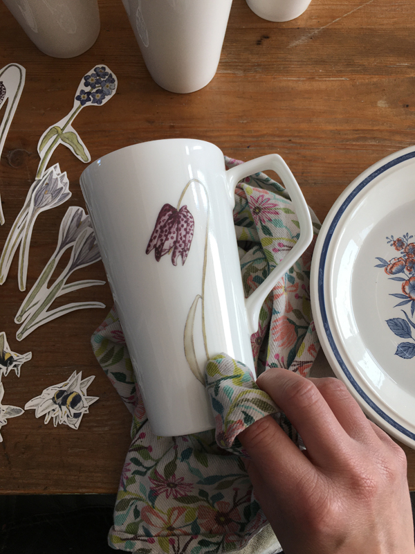 applying ceramic tranfsers of my illustrations to Latte mugs