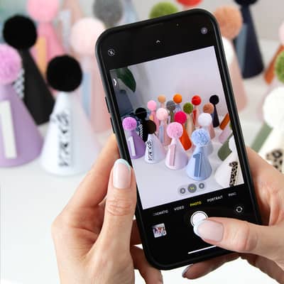 Woman taking a photo of custom personalised first birthday party hats