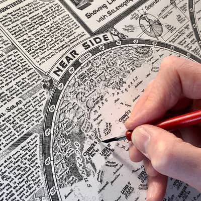 Photo of hand drawing craters on the Moon Map