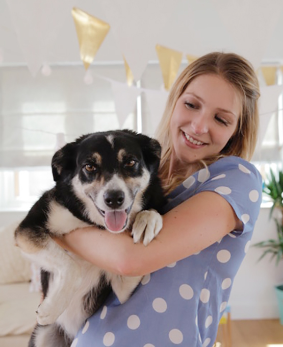 Rose Hall founder of Postbox Party holding her dog