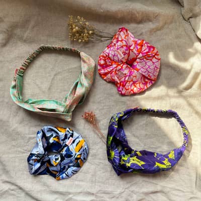 Owner of OlaOla, ola writing inside a lined hardcover A5 notebooks with other notebooks o na desk