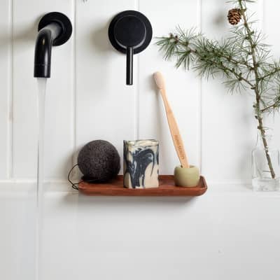 Ecofriendly bathroom essentials. Plastic free 100% natural Konjac sponge, activated charcoal and pine needle soap bar and bamboo toothbrush.