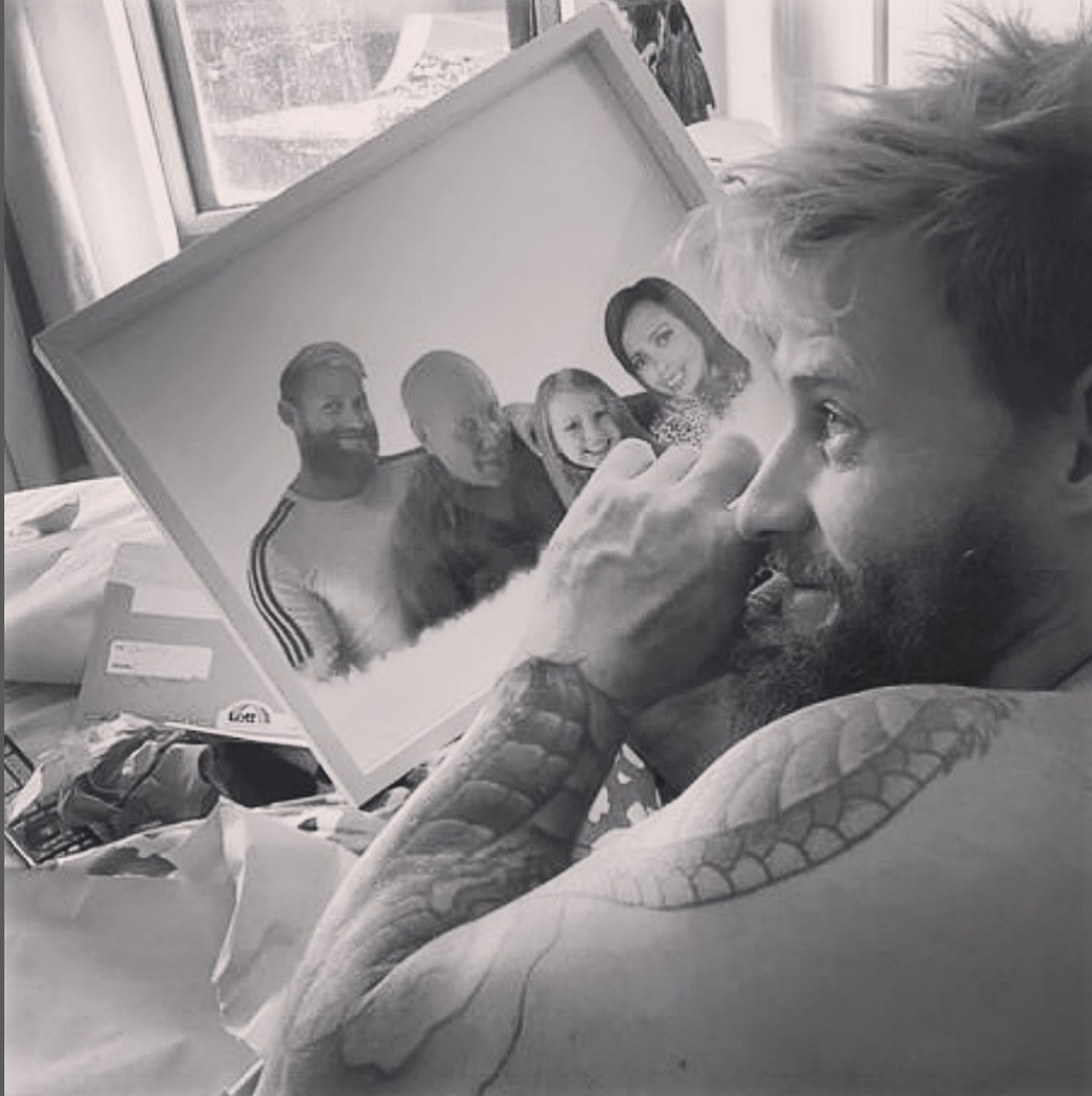 Emotional moment of a man holding a framed blended photo merge, wiping away a tear.