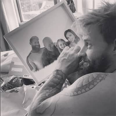 Emotional moment of a man holding a framed blended photo merge, wiping away a tear.