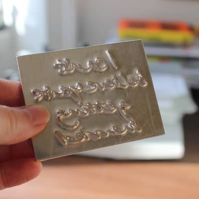 Each phrase is handwritten adn made into a metal die before being traditionally hand printed.