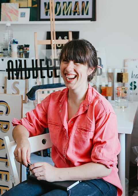 Letters by Em, Emma in studio, smiling in pink shirt