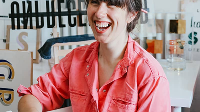 Letters by Em, Emma in studio, smiling in pink shirt