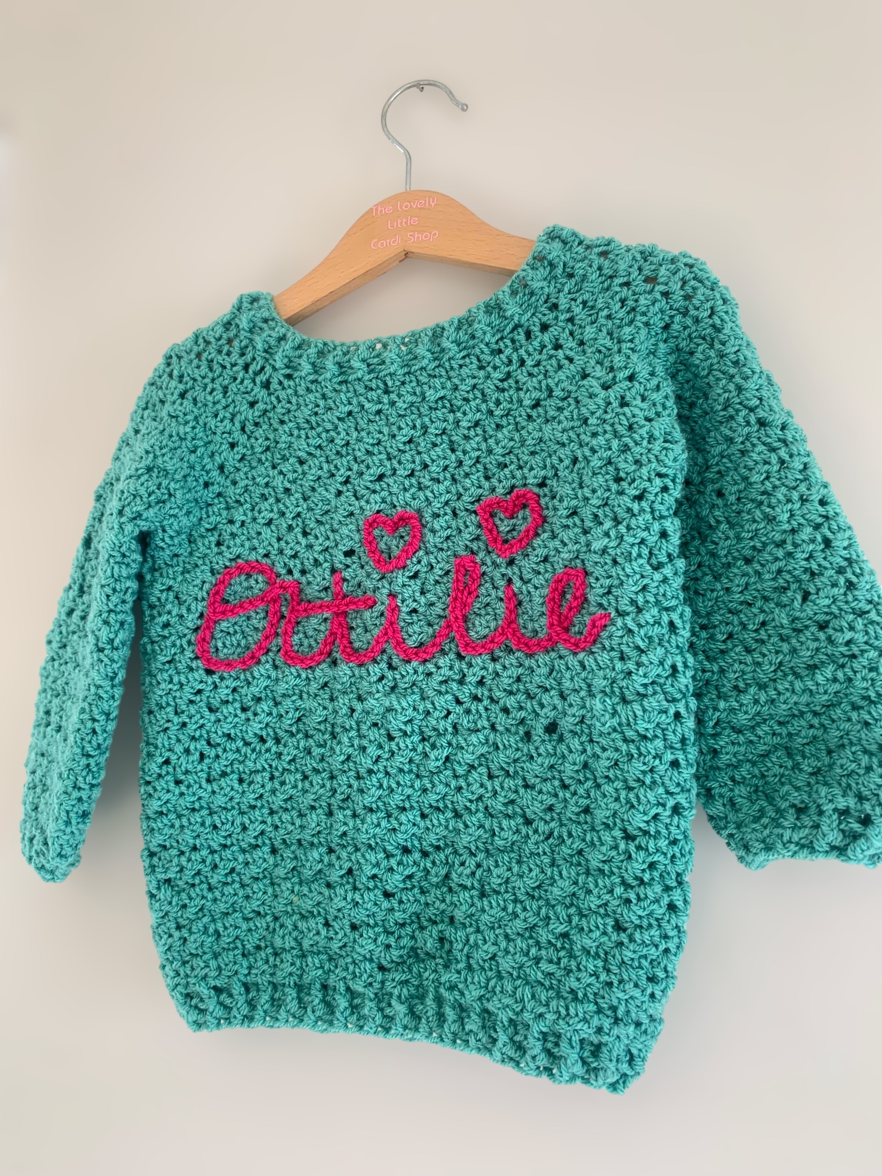 Hand crochet baby cardigan with name hand embroidered onto the back 