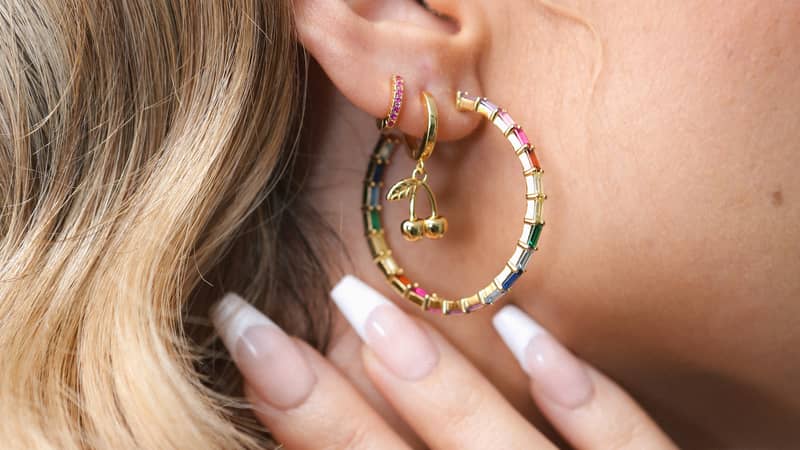 Model wearing Lucky Eleven rainbow gem earrings and ring.