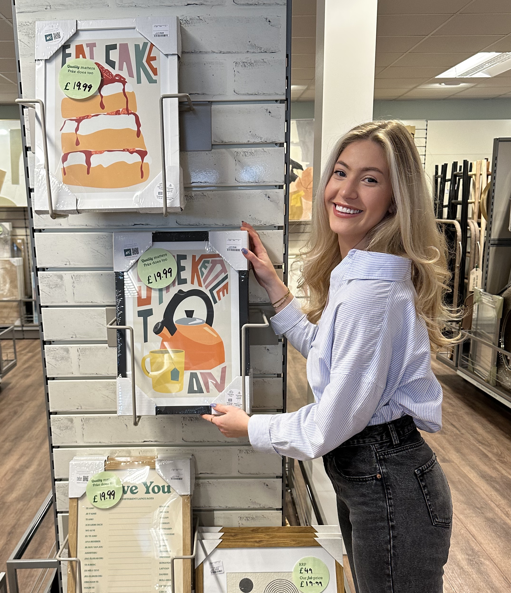 Me holding a framed print that is for sale in Homesense high street store