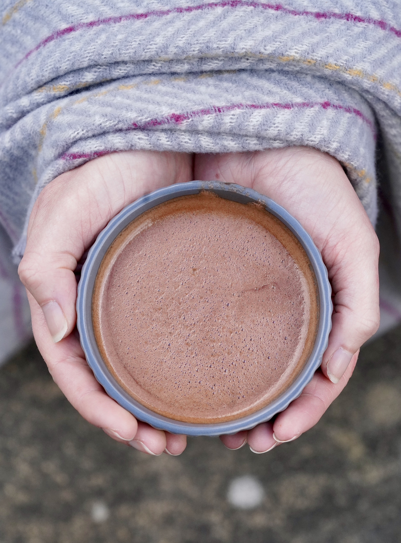 warming hands wrapped around a mug