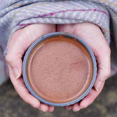 warming hands wrapped around a mug