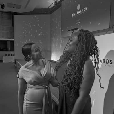 Co-founders Maria and Amone link arms at an award ceremony