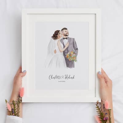 A personalized wedding portrait featuring a couple in elegant attire, held in a white frame.