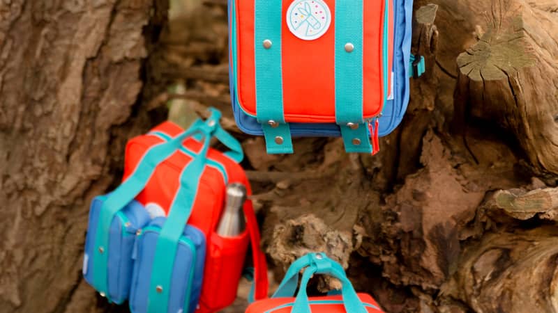 Three magnetic backpacks hanging in a tree