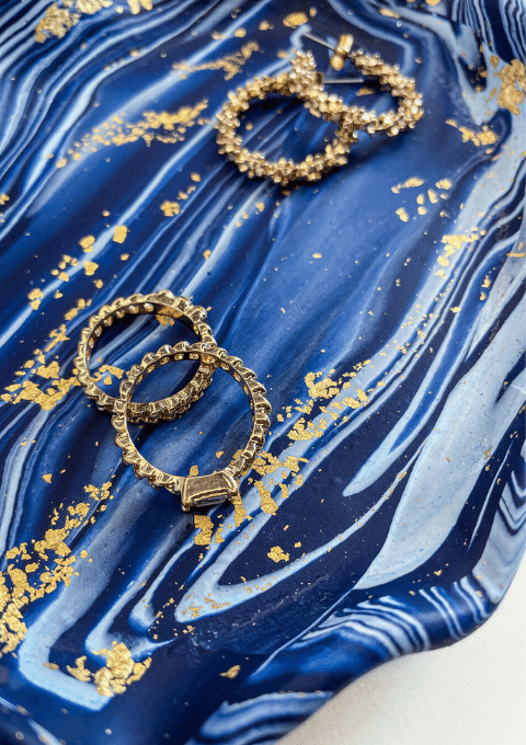 blue marble jewellery tray with rings and hoop earrings