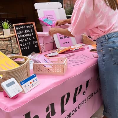 Image of Market Stall setup with Happy Boxx banner and products displayed