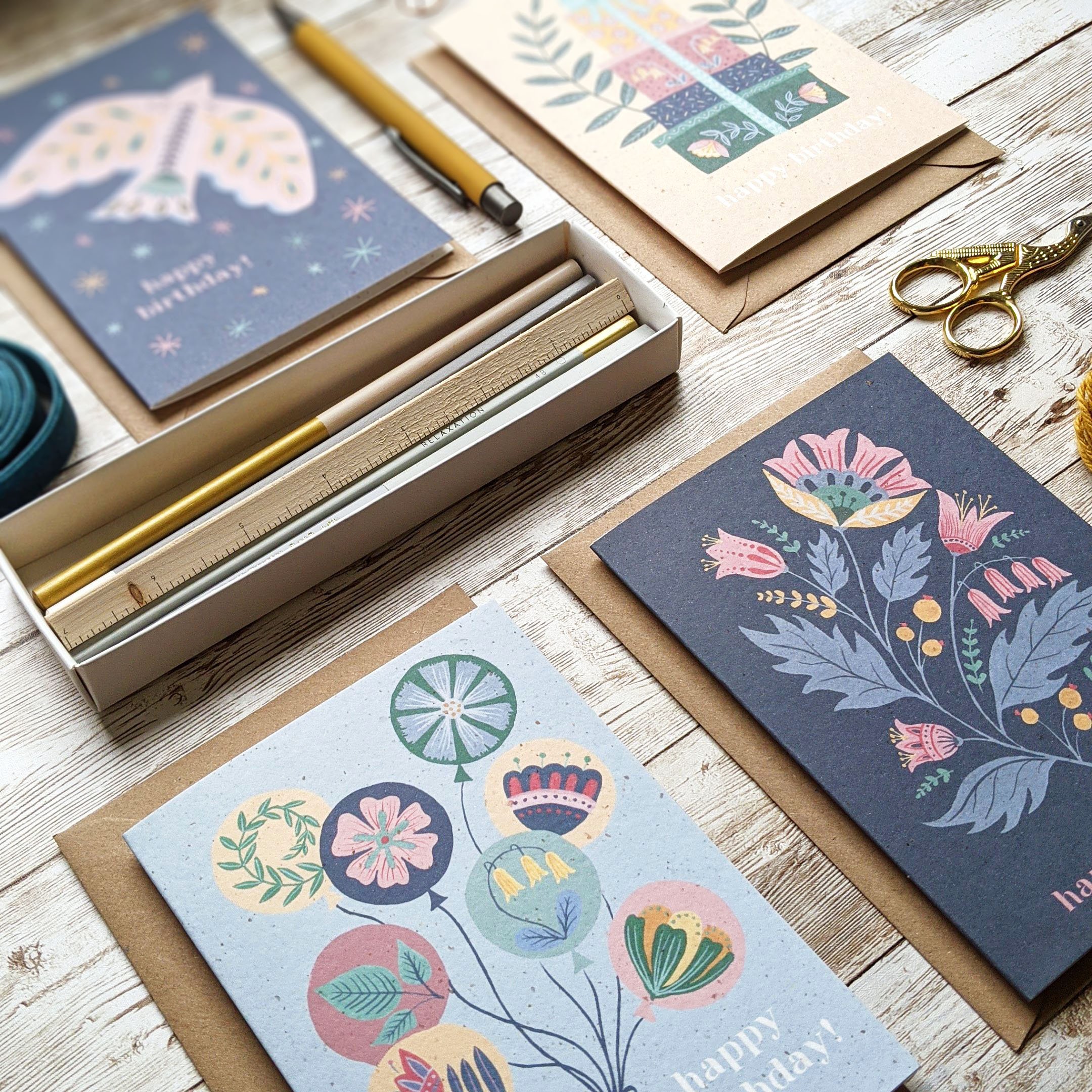 A selection of folk art birthday cards lying on a tabletop